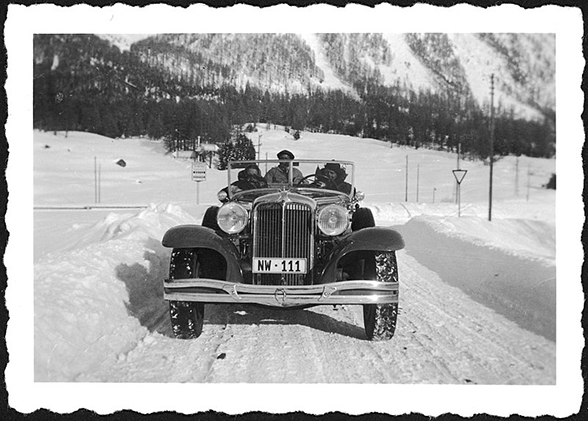Automobil mit drei Personen, mit Kontrollschild NW 111, unterwegs im winterlichen Engadin