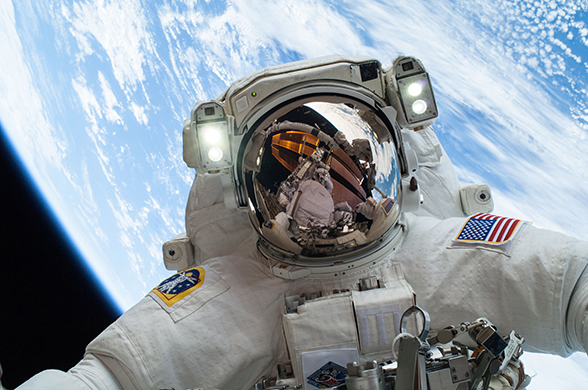 An astronaut posing in space with the Earth in the background. There is probably a bit of Velcro fastener attached somewhere on his suit. 