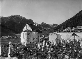 Müstair, Ansicht der Heiligkreuzkapelle über den Friedhof hinweg, Fotografie Robert Durrer, um 1905.