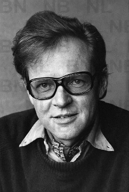 Portrait d’Otto F. Walter portant des lunettes et un pull-over foncé sur une chemise claire