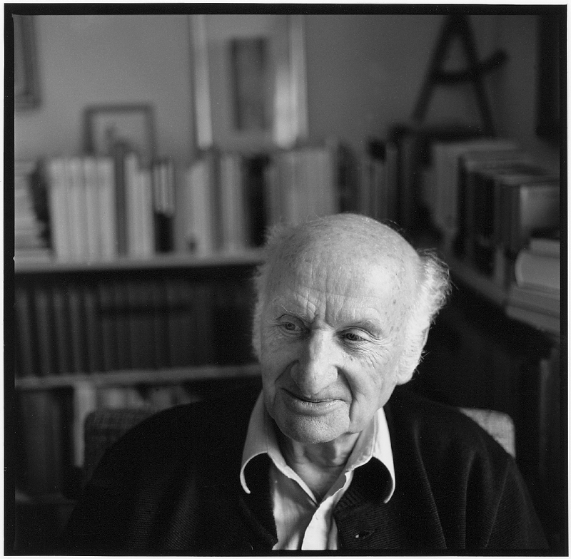 Portrait de Gerhard Meier à son bureau à Niederbipp. À l’arrière-plan, quelques rayons de sa bibliothèque