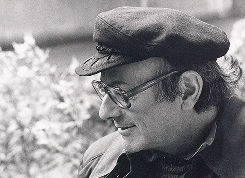 Walter Vogt souriant et portant la casquette ; à l’arrière-plan, un massif en fleurs.