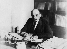 Lenin an seinem Schreibtisch im Kreml, 1918. Wikimedia Commons, gemeinfrei, fotografiert aus: Isaac McBride: Barbarous Soviet Russia, Th. Seltzer, New York, 1920